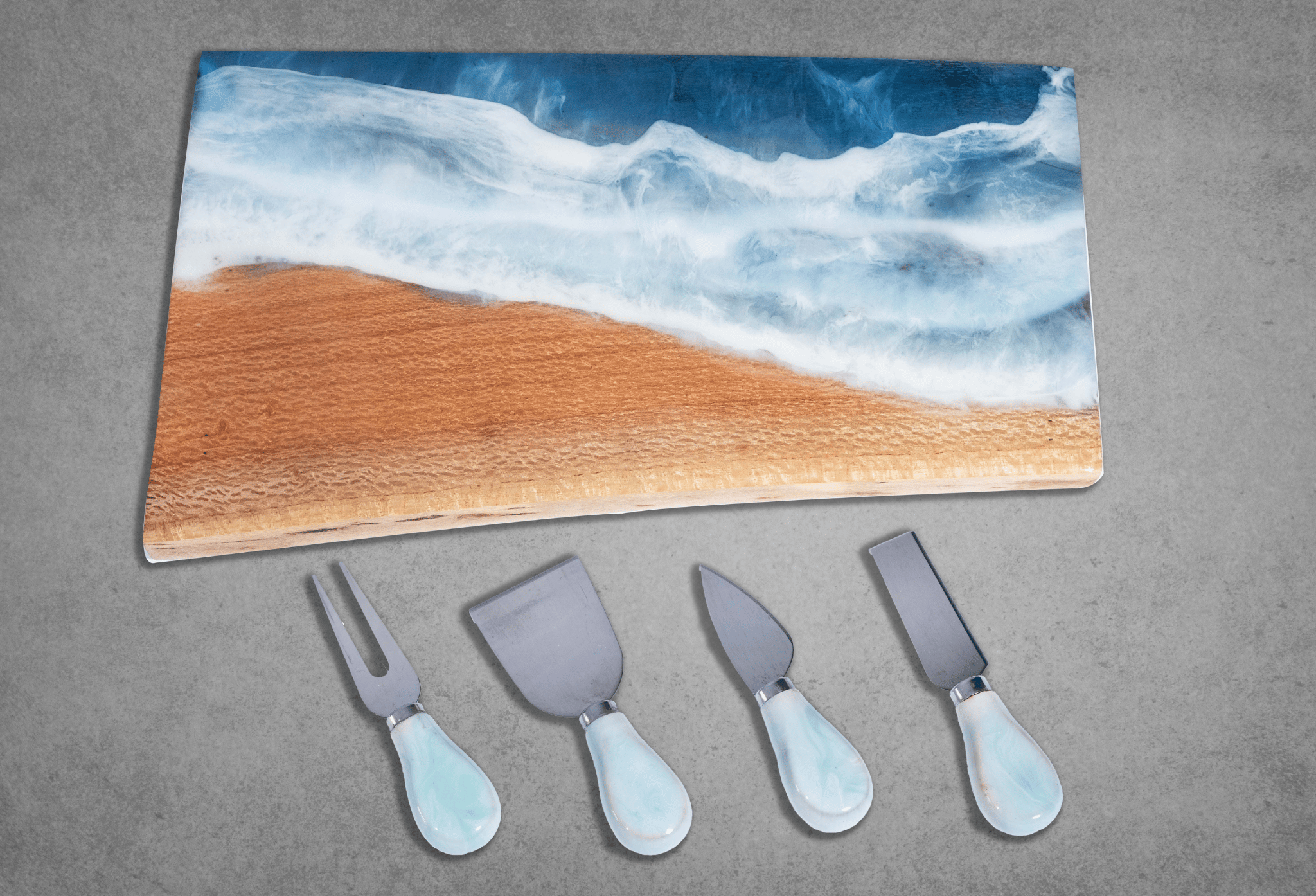 Set of stainless steel cheese knives with complimentary colors matching resin covered cheeseboard